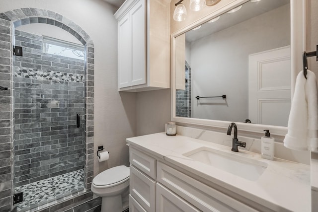 full bath featuring vanity, toilet, and a stall shower