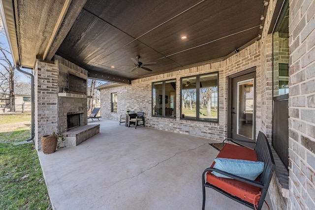 view of patio / terrace with a ceiling fan and an outdoor brick fireplace