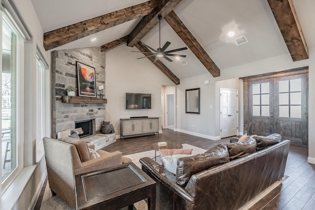 living room with plenty of natural light, a fireplace, visible vents, and wood finished floors