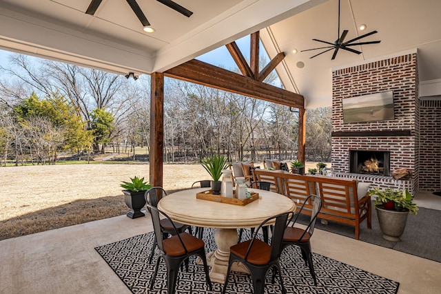 view of patio with outdoor dining area, fence, an outdoor brick fireplace, and ceiling fan