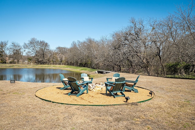 view of community with an outdoor fire pit and a water view