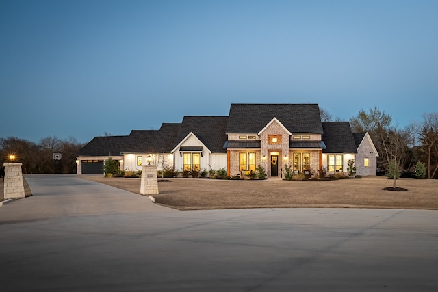 view of front of house with metal roof, a garage, concrete driveway, and a standing seam roof