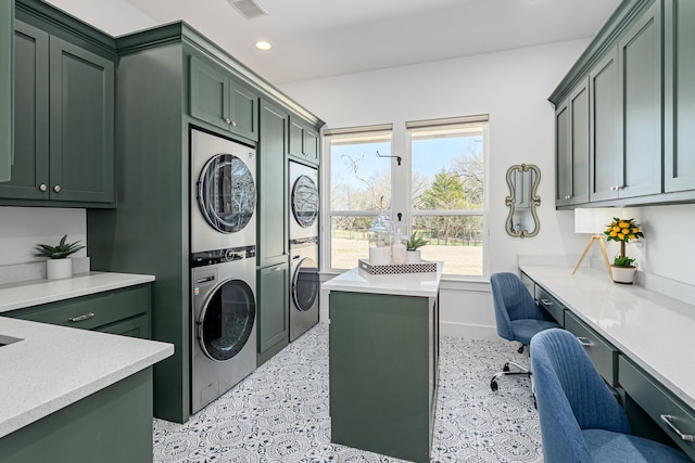 clothes washing area featuring recessed lighting, stacked washer / dryer, cabinet space, and visible vents