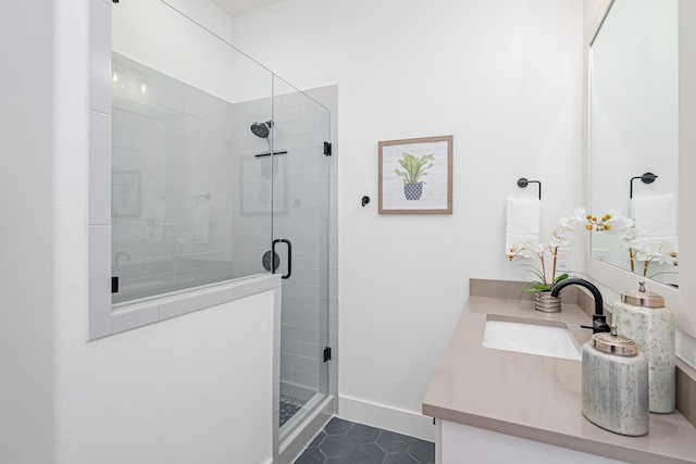 full bath with vanity, a shower stall, baseboards, and tile patterned floors