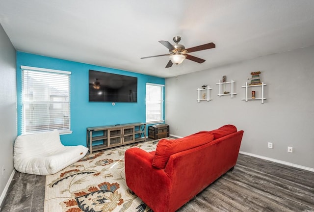 living area featuring baseboards, wood finished floors, and a ceiling fan