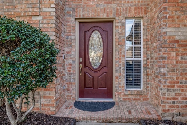 entrance to property featuring brick siding