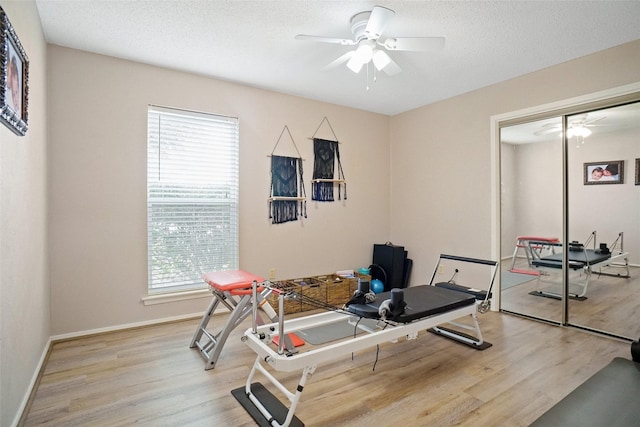 exercise area featuring a ceiling fan, plenty of natural light, and light wood-style floors