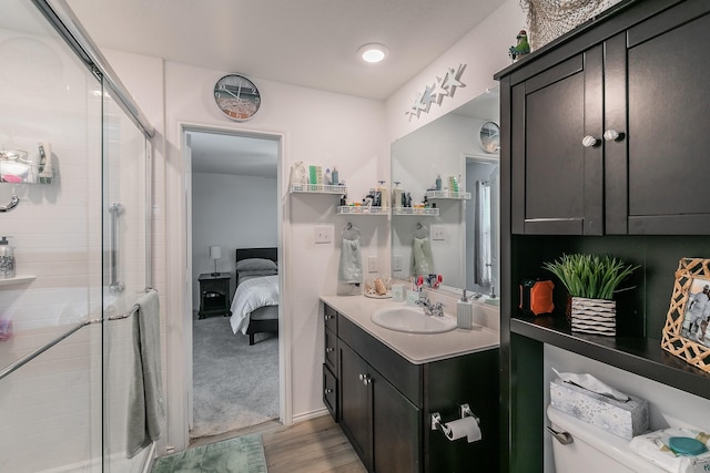 bathroom with toilet, a stall shower, and vanity