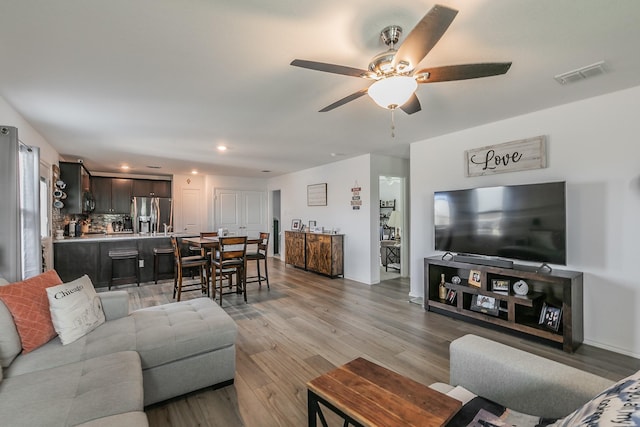 living room with recessed lighting, visible vents, wood finished floors, and a ceiling fan