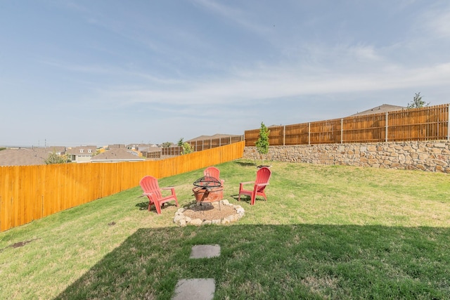 view of yard featuring a fire pit and a fenced backyard