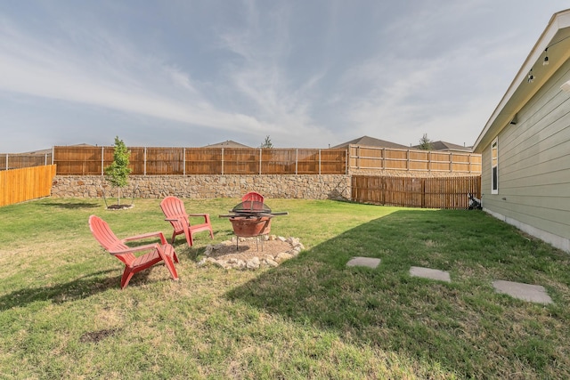 view of yard with a fenced backyard and an outdoor fire pit