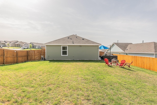 rear view of house featuring a yard, a residential view, and a fenced backyard