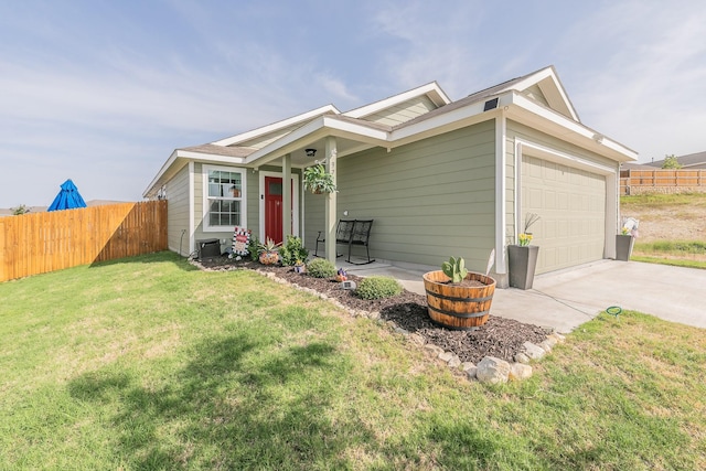 view of front of house with a front yard, an attached garage, fence, and concrete driveway