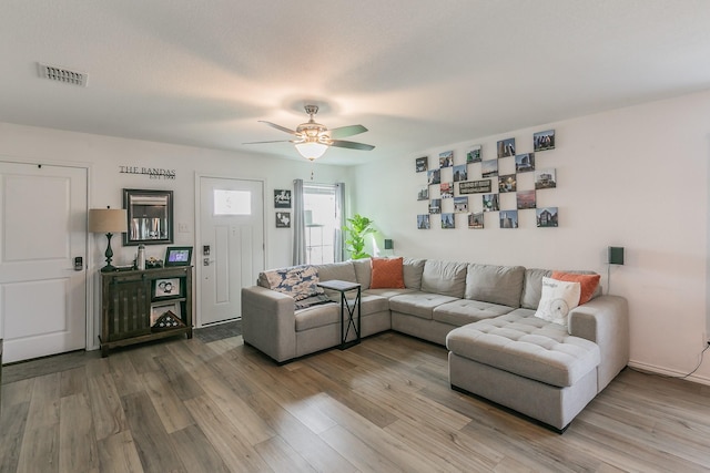 living area with visible vents, light wood-style flooring, and ceiling fan