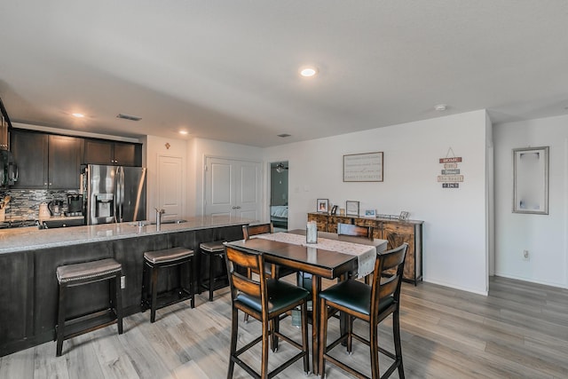 dining area with light wood-style flooring, recessed lighting, visible vents, and baseboards