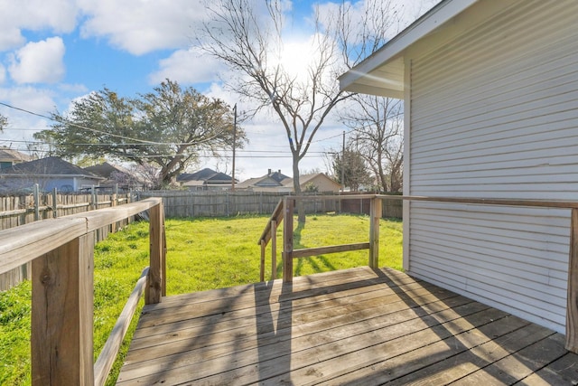 wooden deck featuring a yard, a residential view, and a fenced backyard