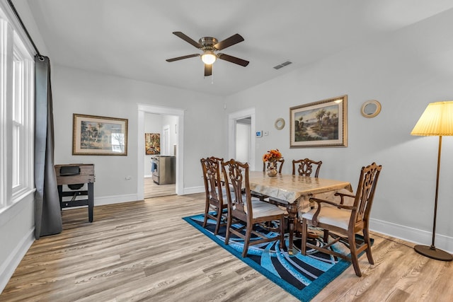 dining space featuring visible vents, baseboards, light wood-style floors, and ceiling fan