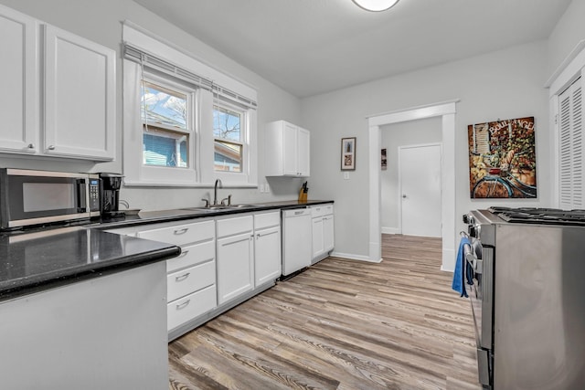 kitchen featuring a sink, stainless steel appliances, white cabinets, and light wood finished floors