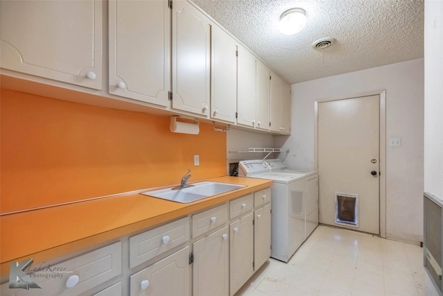 washroom with light floors, visible vents, separate washer and dryer, cabinet space, and a sink