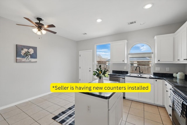 kitchen with light tile patterned floors, visible vents, a sink, black range with electric cooktop, and dark countertops