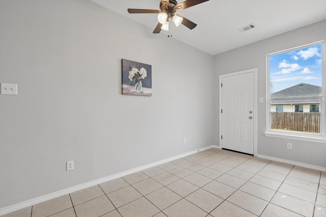 empty room with light tile patterned floors, baseboards, visible vents, and ceiling fan