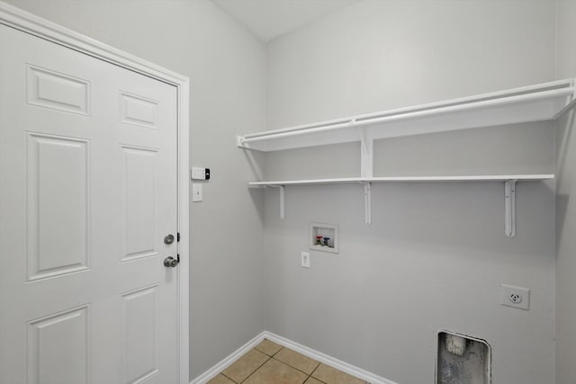 laundry area featuring hookup for a washing machine, baseboards, laundry area, light tile patterned flooring, and electric dryer hookup