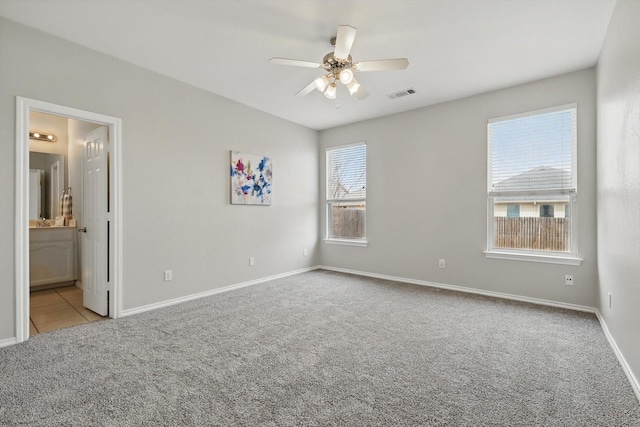 unfurnished bedroom with visible vents, ensuite bathroom, a ceiling fan, carpet, and baseboards