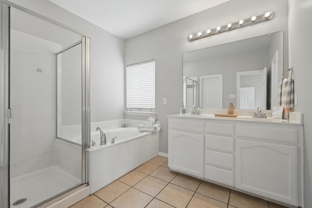 full bathroom with tile patterned floors, a garden tub, a sink, a shower stall, and double vanity