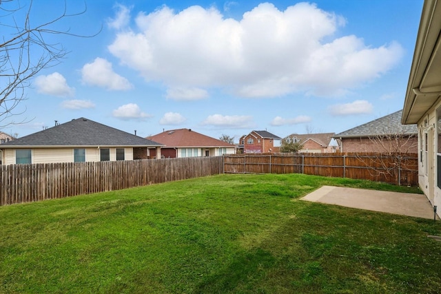 view of yard featuring a patio, a fenced backyard, and a residential view