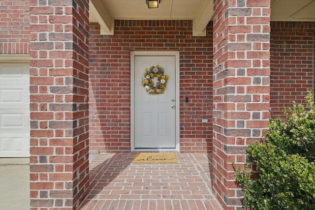 entrance to property featuring brick siding and an attached garage