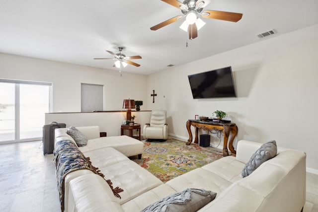 living room with baseboards, visible vents, and ceiling fan