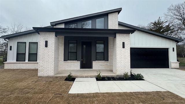 view of front of house with driveway, a porch, brick siding, a garage, and board and batten siding