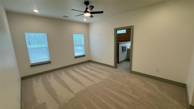 unfurnished room with ceiling fan, baseboards, visible vents, and light carpet