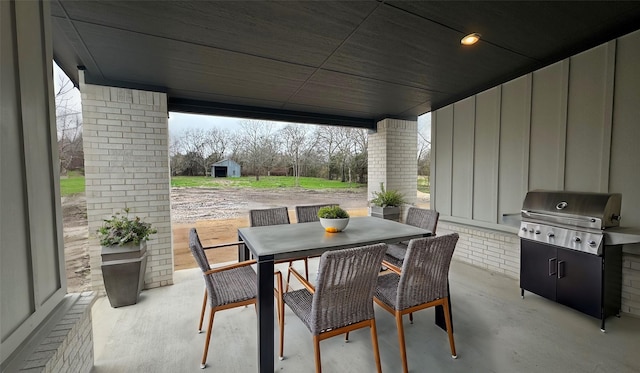 view of patio / terrace featuring outdoor dining area, an outbuilding, a grill, and a shed