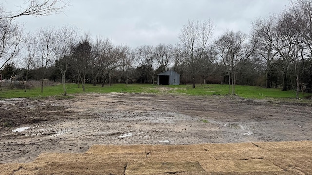 view of yard featuring a rural view, an outdoor structure, and an outbuilding