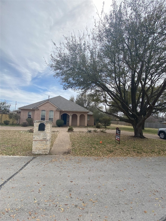 view of front of property with driveway, a garage, and a fenced front yard