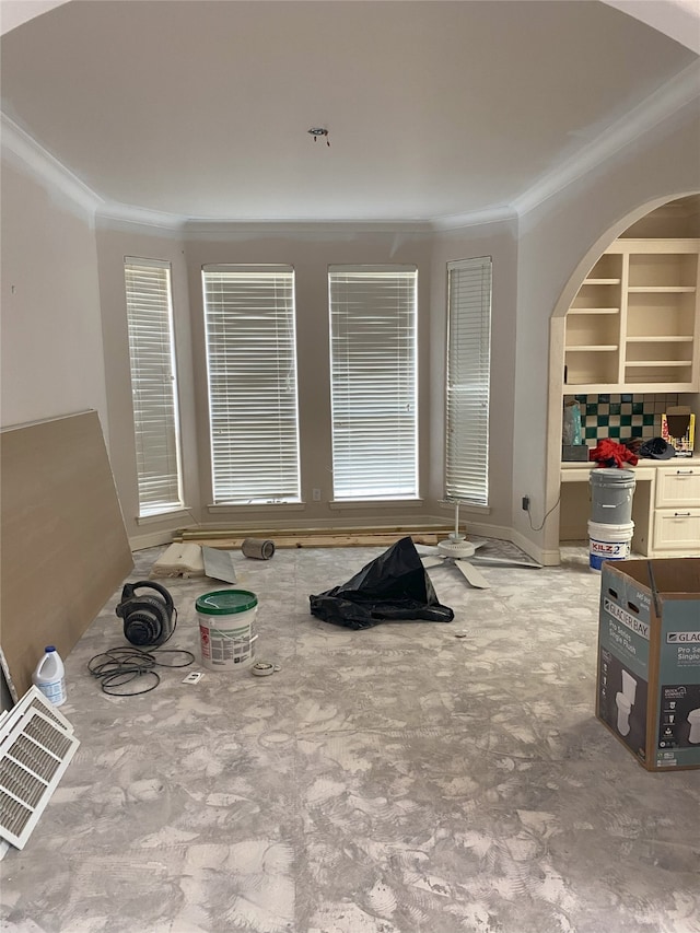 living area with arched walkways, visible vents, and ornamental molding