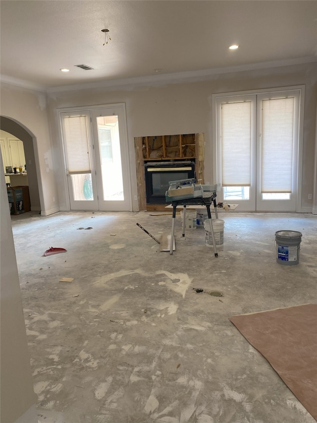 unfurnished living room featuring arched walkways, recessed lighting, and crown molding