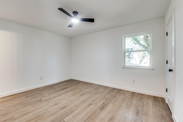 spare room featuring baseboards, light wood-type flooring, and ceiling fan