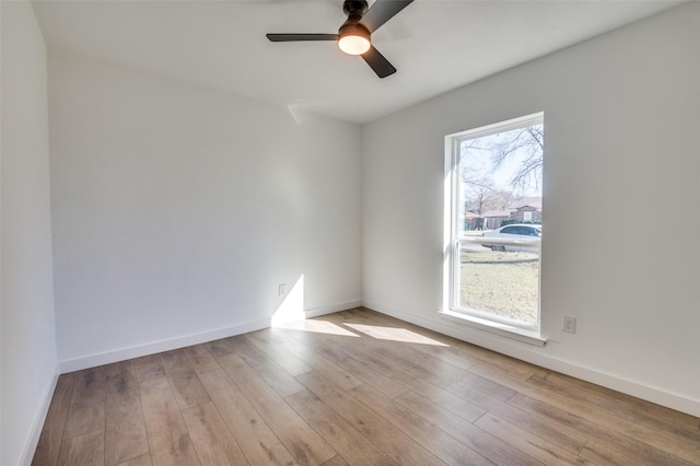 empty room featuring light wood-style flooring, a ceiling fan, and baseboards