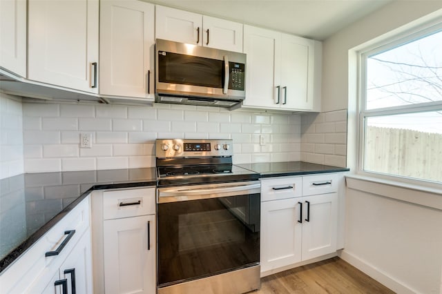 kitchen with light wood-style floors, stainless steel appliances, tasteful backsplash, and white cabinetry