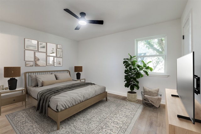 bedroom featuring baseboards, light wood-type flooring, and ceiling fan