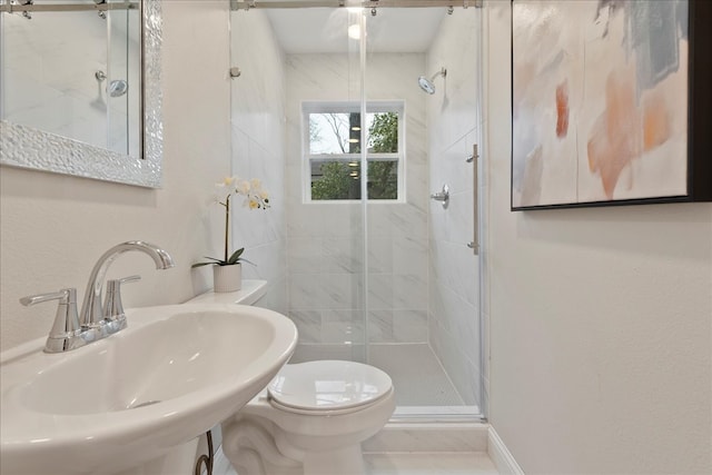 full bath featuring a stall shower, toilet, and a sink