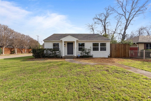 view of front of home with brick siding, a front yard, and fence