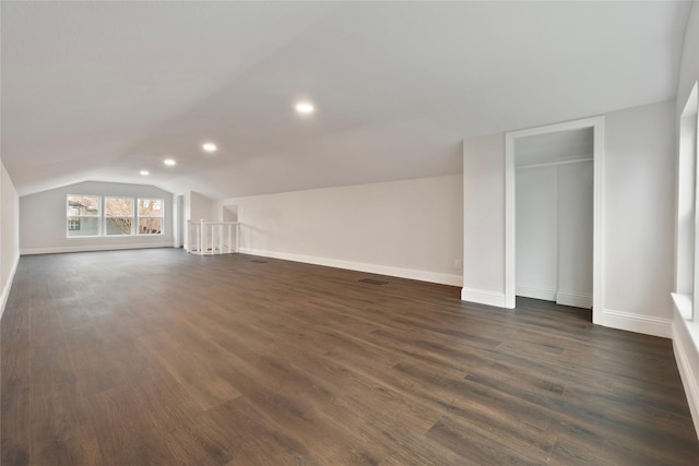 interior space featuring recessed lighting, baseboards, dark wood finished floors, and vaulted ceiling