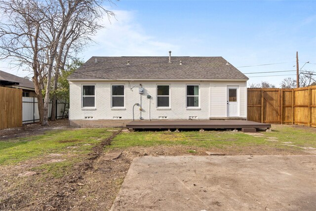 back of property featuring a wooden deck, brick siding, a fenced backyard, and a yard