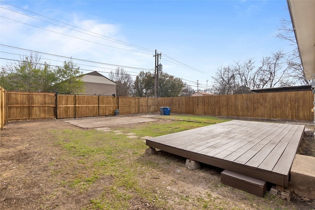 view of yard with a patio, a wooden deck, and a fenced backyard