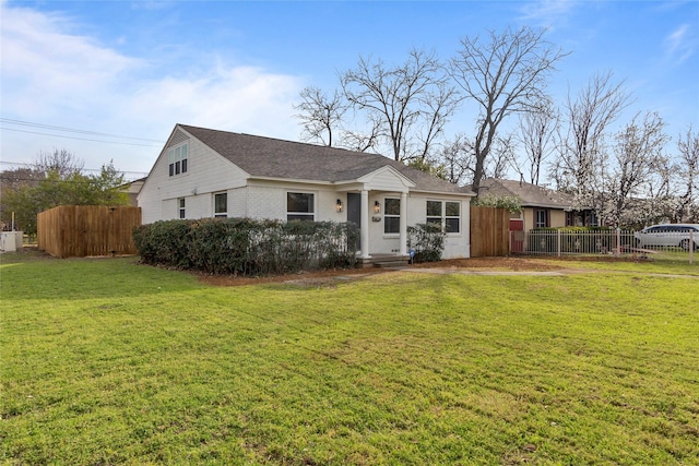 view of front of house featuring roof with shingles, a front lawn, and fence