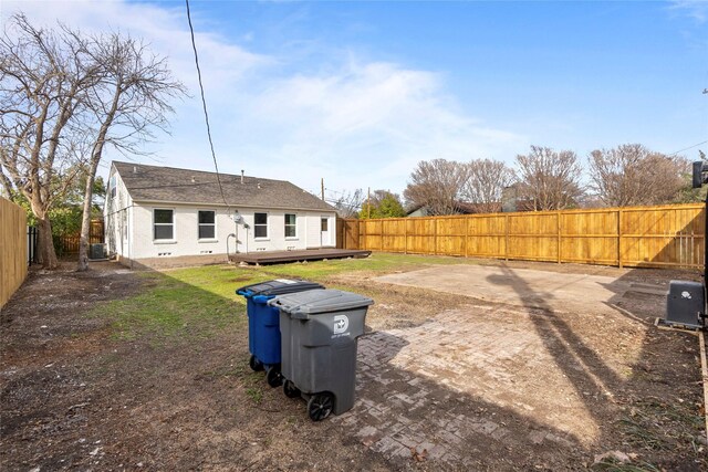 rear view of house featuring central air condition unit, a lawn, a wooden deck, and a fenced backyard