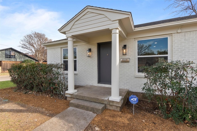 entrance to property featuring brick siding